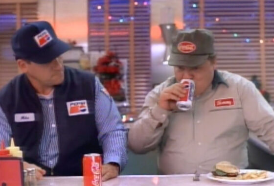 Superbowl ad still of a Pepsi driver and a Coke driver compare sodas in a diner. 